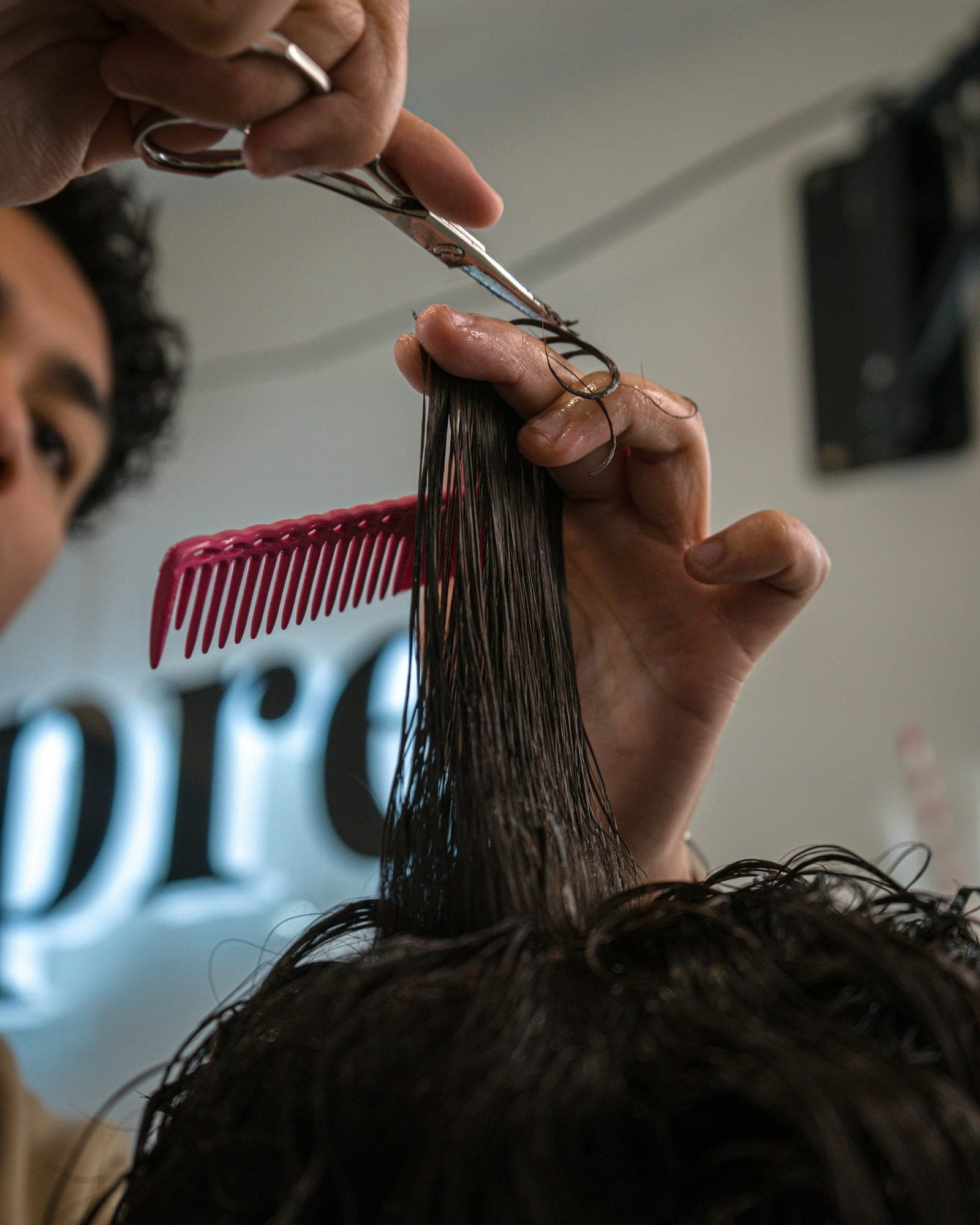 Coupe aux ciseaux, peigne rose à la main